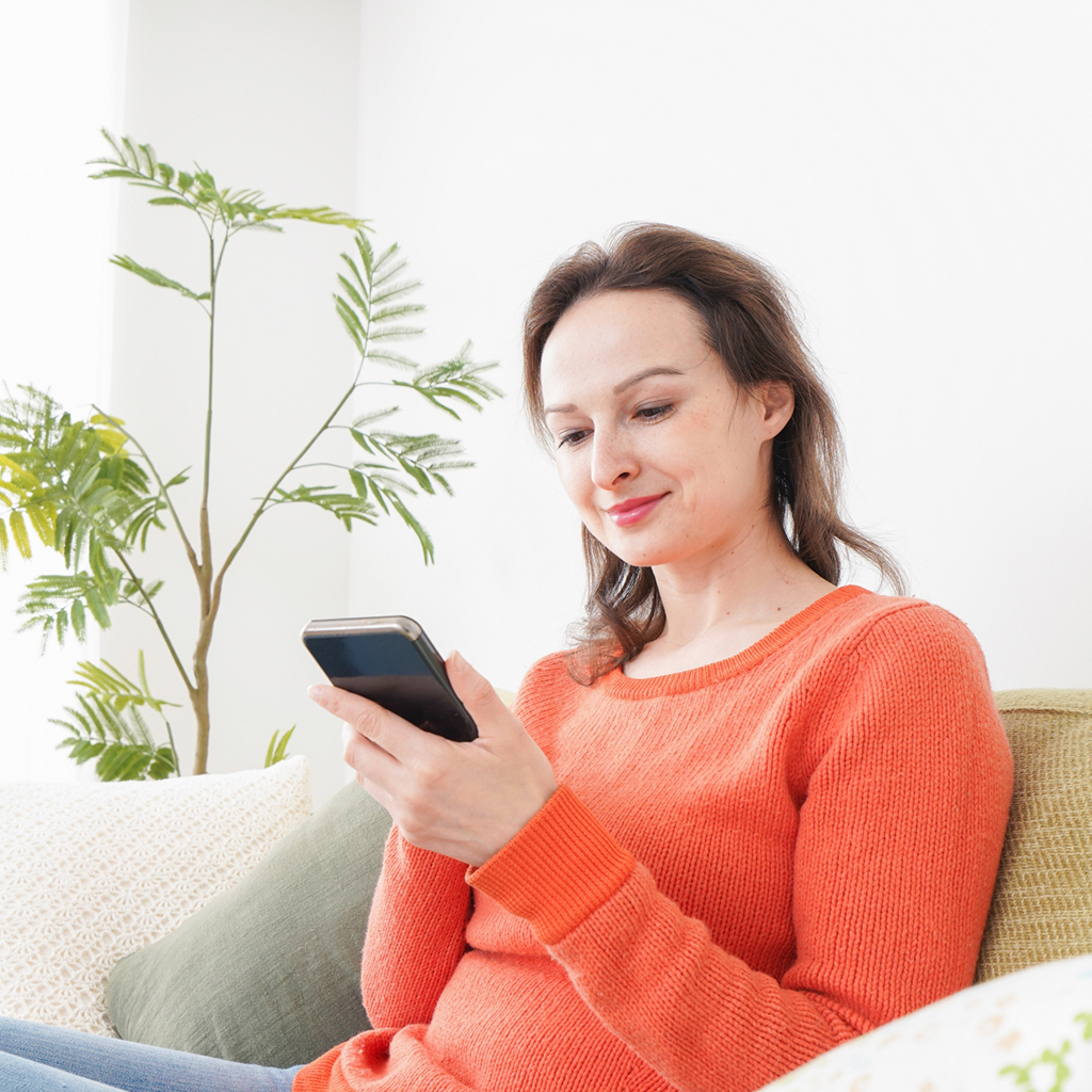 笑顔でスマホを見る女性