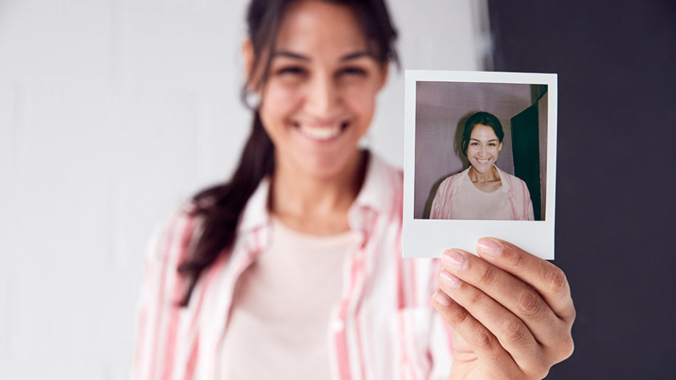 ポラロイド写真を持つ女性