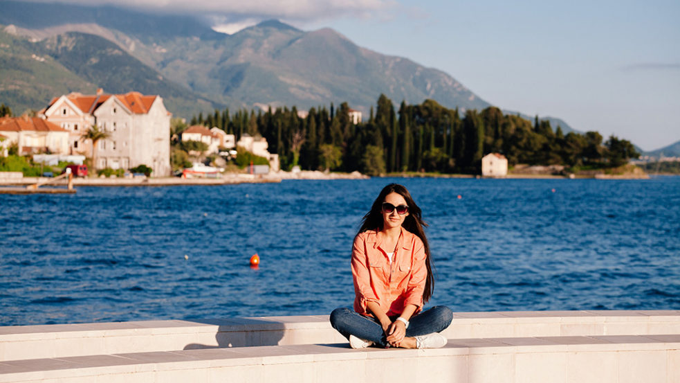 湖を背景に座る女性
